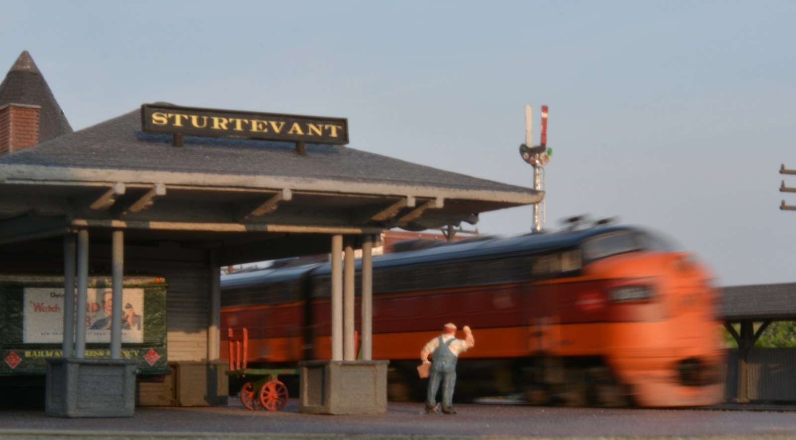 Train blurs past the Sturtevant depot as the agent waves on the Modutrak Sturtevant module